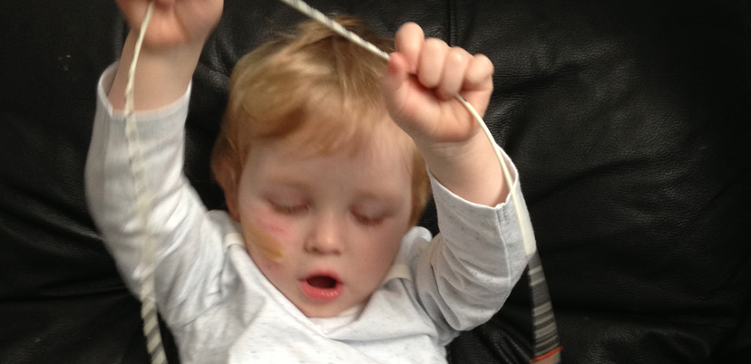 Little boy playing with feeding tube
